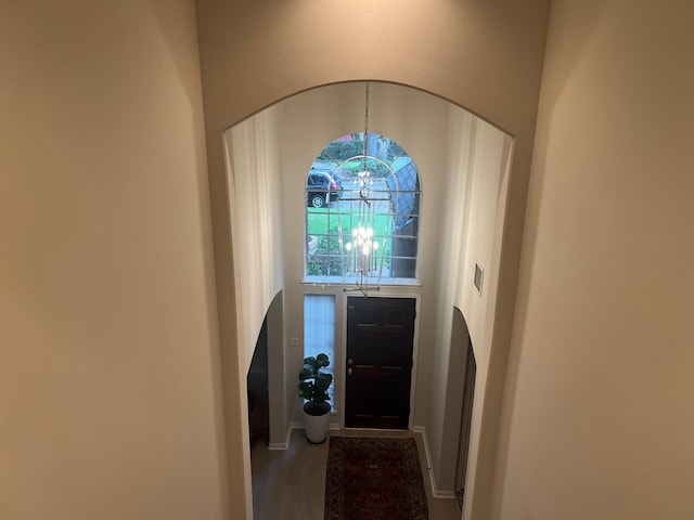 foyer with an inviting chandelier and hardwood / wood-style flooring