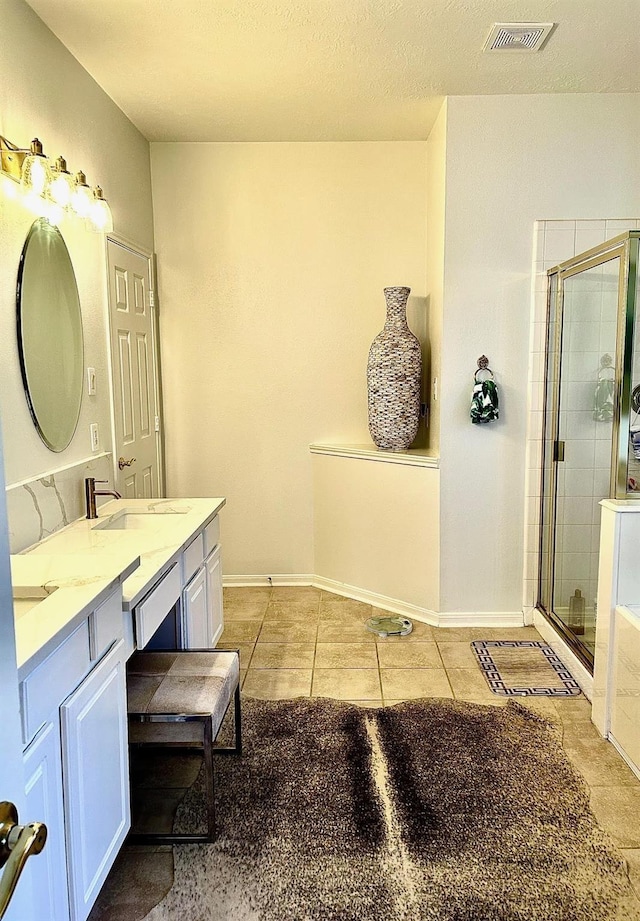 bathroom featuring vanity, tile patterned flooring, and a shower with door