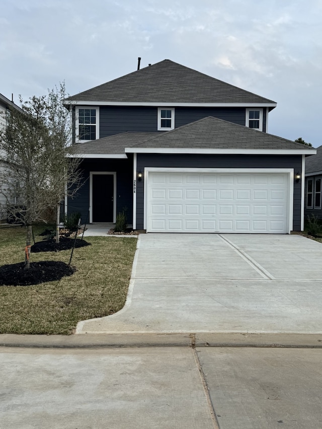 view of property featuring a garage and a front yard