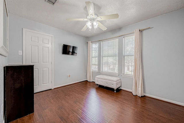 interior space with ceiling fan, a textured ceiling, and dark hardwood / wood-style flooring