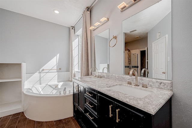 bathroom featuring vanity and a washtub