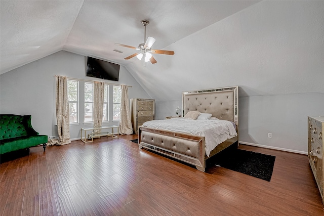 bedroom with hardwood / wood-style floors, a textured ceiling, vaulted ceiling, and ceiling fan