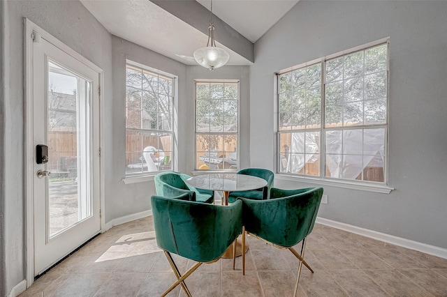 tiled dining space with lofted ceiling