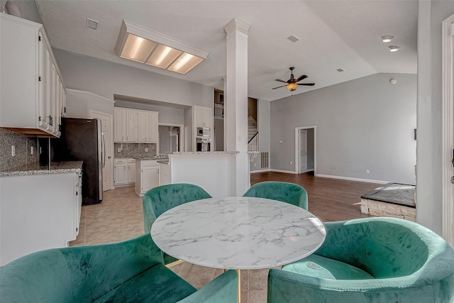 dining area with lofted ceiling, ceiling fan, and ornate columns