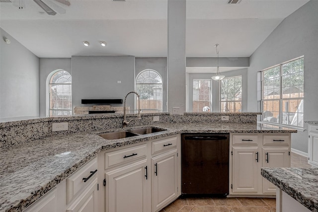 kitchen with plenty of natural light, white cabinetry, dishwasher, sink, and light stone countertops