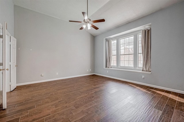 empty room featuring ceiling fan, dark hardwood / wood-style floors, and vaulted ceiling