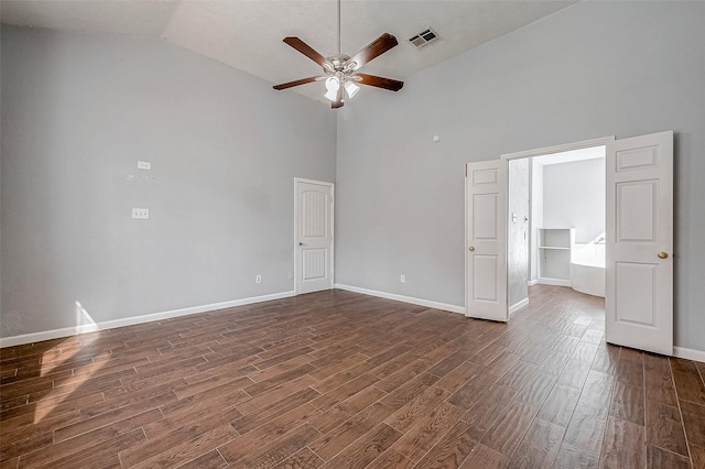 empty room with ceiling fan, high vaulted ceiling, and dark hardwood / wood-style flooring