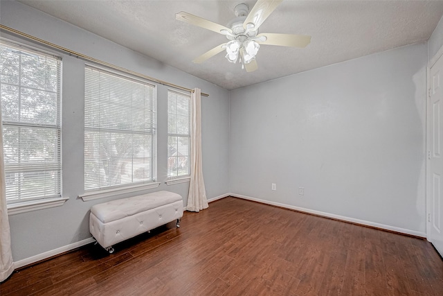 unfurnished room with ceiling fan, dark hardwood / wood-style flooring, and a textured ceiling