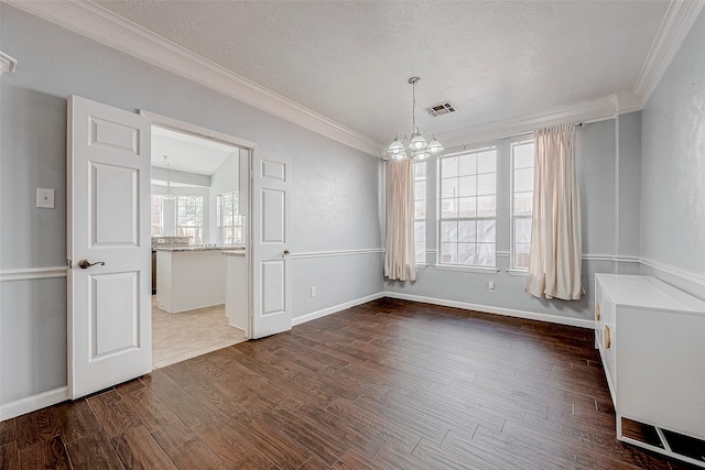 unfurnished room featuring dark hardwood / wood-style flooring, a notable chandelier, crown molding, and a textured ceiling