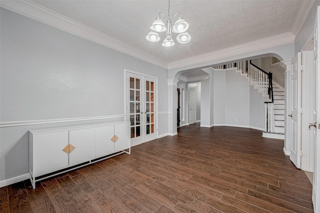 spare room featuring french doors, crown molding, a chandelier, a textured ceiling, and dark hardwood / wood-style floors