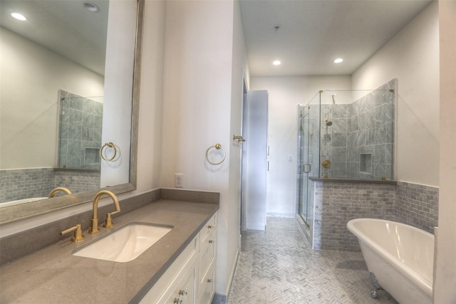 bathroom with tile patterned floors, vanity, shower with separate bathtub, and tile walls