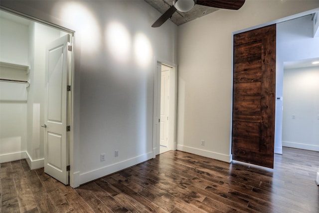 empty room with ceiling fan and dark hardwood / wood-style flooring