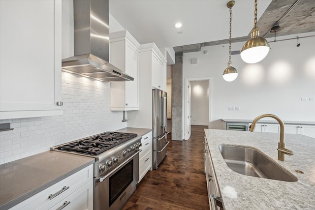 1714 Ashland Unit 303, Houston, TX 77008 - kitchen featuring wall chimney range hood, decorative light fixtures, a sink, premium appliances, and white cabinetry