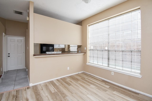 unfurnished room with sink and light hardwood / wood-style floors