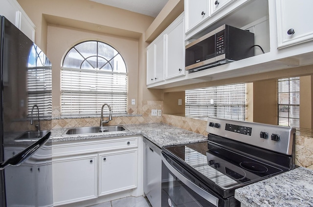 kitchen featuring light stone counters, sink, stainless steel appliances, and white cabinets