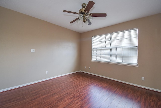 unfurnished room featuring dark wood-type flooring and ceiling fan