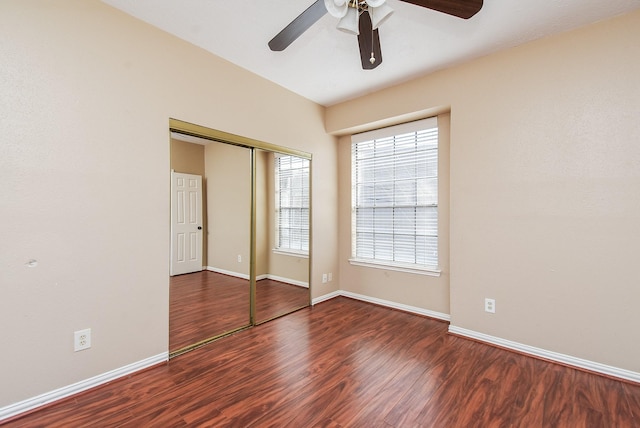 unfurnished bedroom featuring dark wood-type flooring, ceiling fan, and a closet