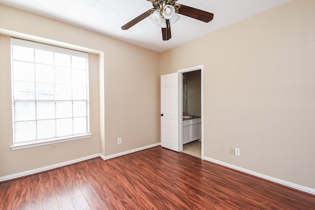 spare room featuring dark wood-type flooring, ceiling fan, and a textured ceiling