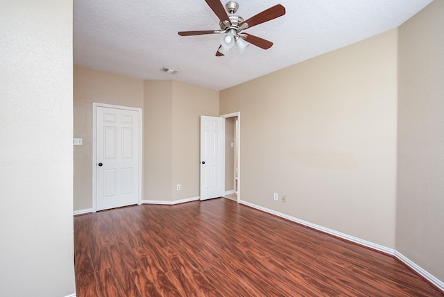 unfurnished room featuring ceiling fan, dark hardwood / wood-style floors, and a textured ceiling