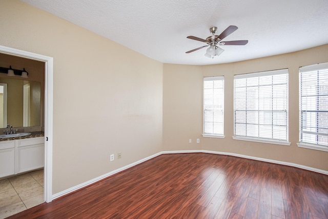 unfurnished room with ceiling fan, sink, and light wood-type flooring