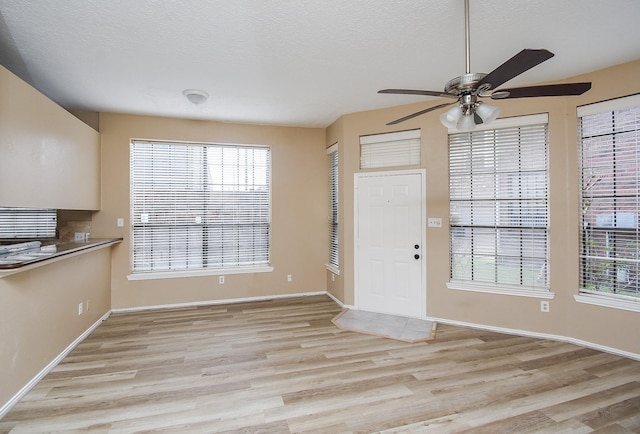 foyer featuring ceiling fan, a textured ceiling, and light hardwood / wood-style floors