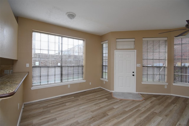 foyer entrance with ceiling fan and light wood-type flooring