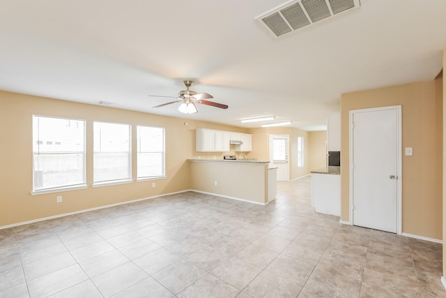 unfurnished living room featuring light tile patterned floors and ceiling fan