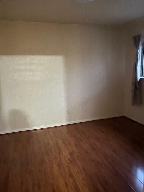 spare room featuring dark wood-type flooring