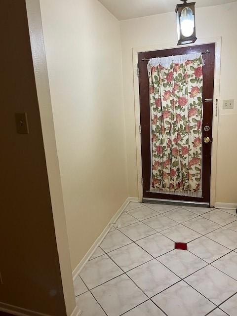 doorway to outside with light tile patterned floors