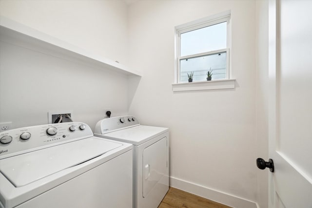 laundry room with baseboards, laundry area, wood finished floors, and washer and dryer