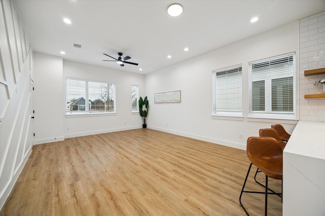 living room featuring baseboards, light wood-type flooring, and recessed lighting