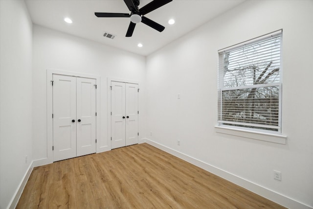 unfurnished bedroom featuring recessed lighting, two closets, visible vents, and baseboards