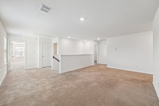 carpeted spare room with a textured ceiling