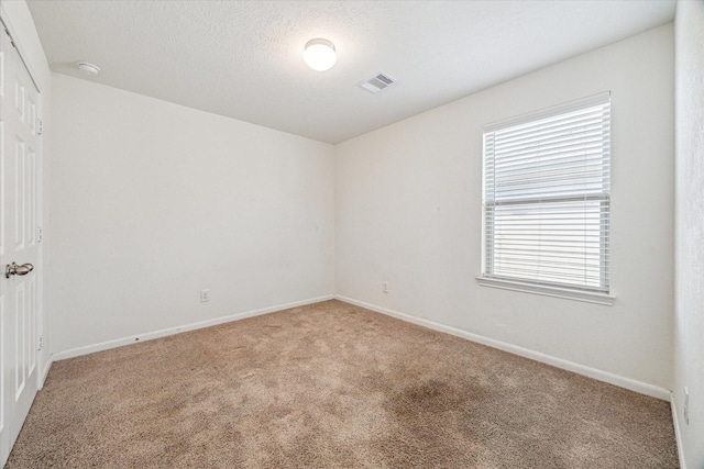 unfurnished room featuring a textured ceiling and carpet flooring