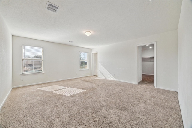 carpeted spare room with a textured ceiling