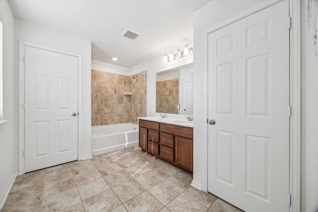 bathroom with tiled shower / bath combo, vanity, and tile patterned floors