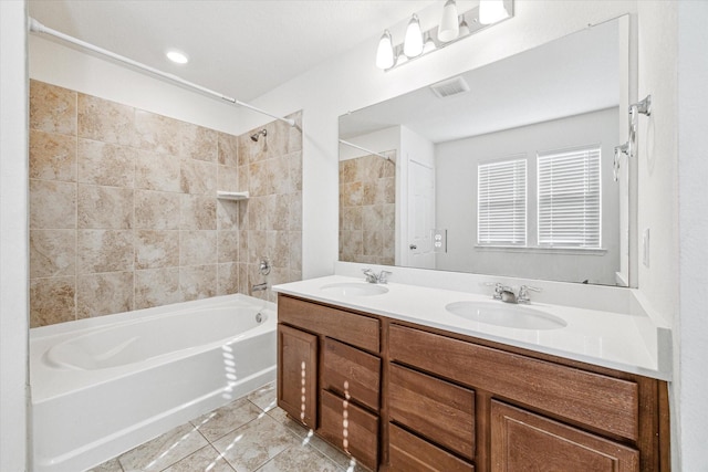 bathroom with tiled shower / bath and vanity