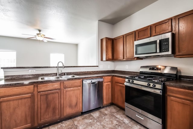 kitchen featuring appliances with stainless steel finishes, sink, light tile patterned floors, and ceiling fan
