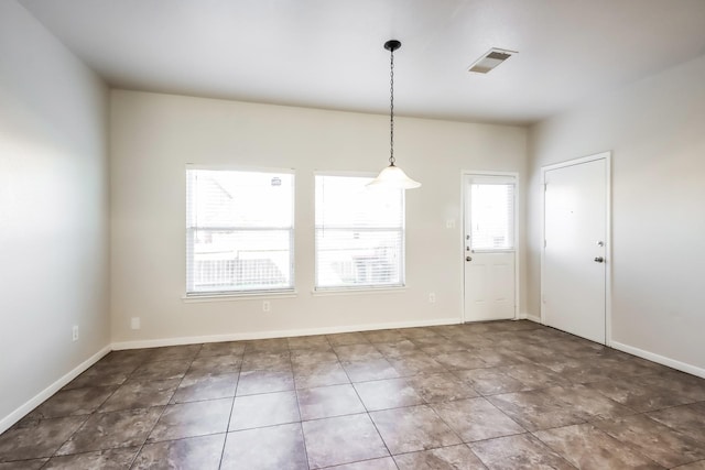 unfurnished dining area with dark tile patterned flooring
