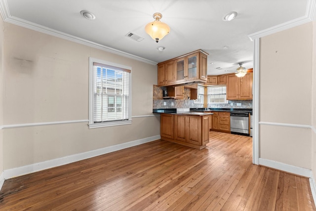 kitchen with brown cabinets, dark countertops, stainless steel dishwasher, glass insert cabinets, and a peninsula