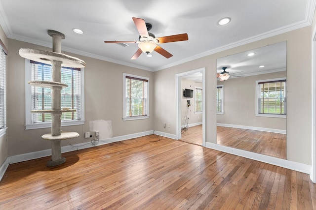 unfurnished room with plenty of natural light, crown molding, baseboards, and wood finished floors