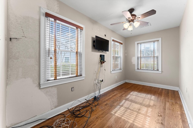 spare room with a ceiling fan, baseboards, and wood finished floors