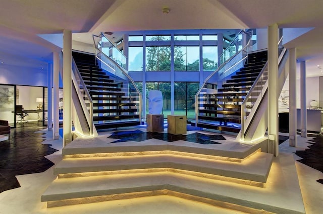 stairway with concrete flooring and a high ceiling