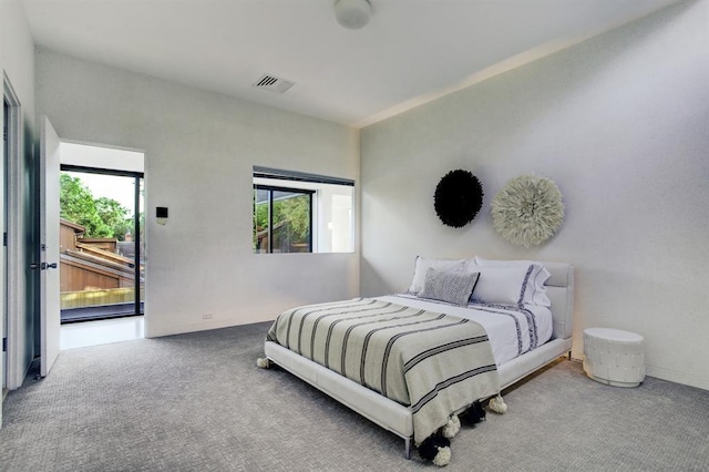 bedroom with multiple windows, access to outside, and carpet flooring