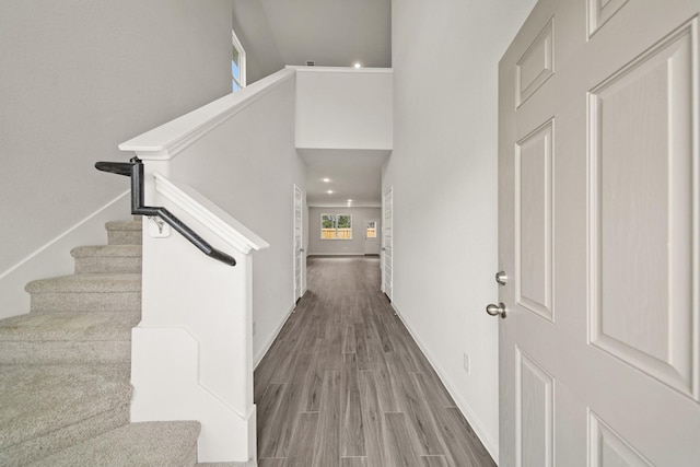 entryway featuring stairs, baseboards, and wood finished floors