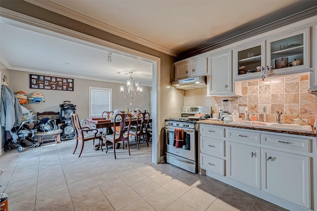 kitchen featuring white cabinetry, stainless steel gas range oven, ornamental molding, and sink