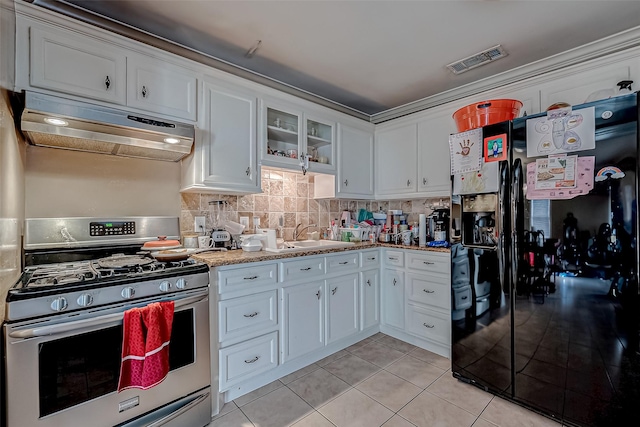 kitchen featuring sink, gas stove, white cabinetry, black refrigerator with ice dispenser, and backsplash