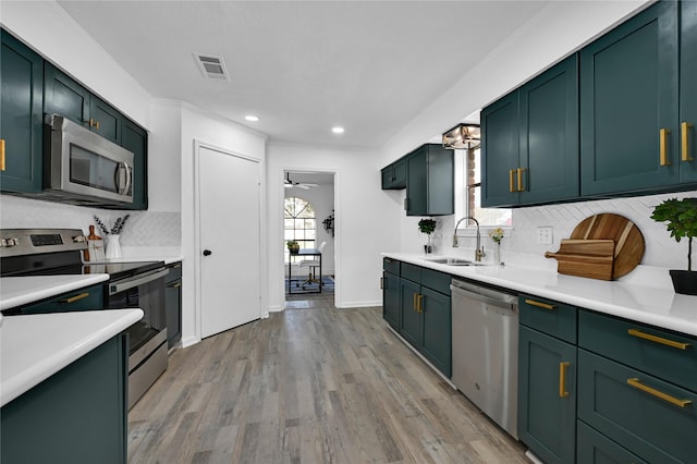 kitchen with stainless steel appliances, light countertops, a sink, and visible vents