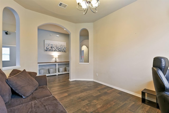 living room with a notable chandelier and dark hardwood / wood-style floors