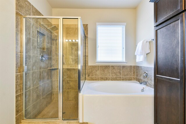 bathroom featuring separate shower and tub